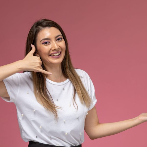 front-view-young-female-white-shirt-showing-phone-call-pose-pink-wall-color-woman-pose-model